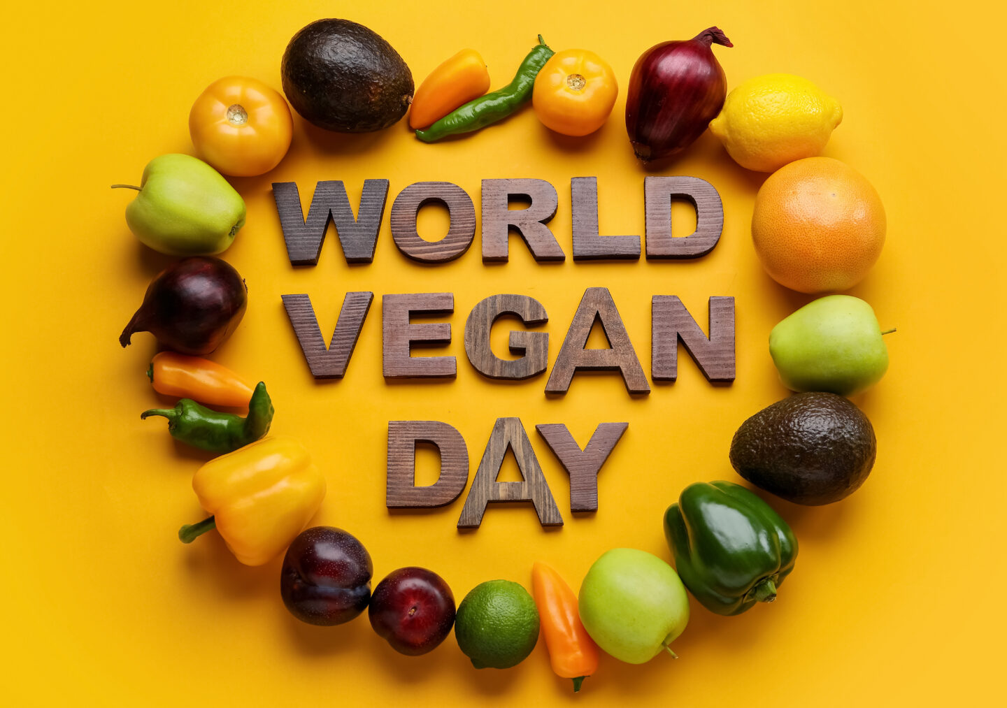 Text WORLD VEGAN DAY made of wooden letters, ripe fruits and vegetables on color background