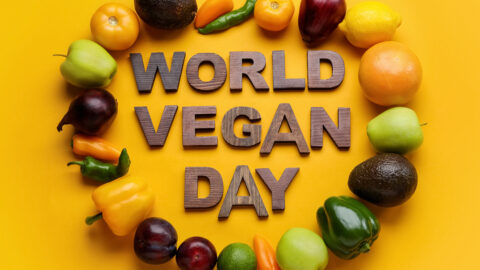 Text WORLD VEGAN DAY made of wooden letters, ripe fruits and vegetables on color background